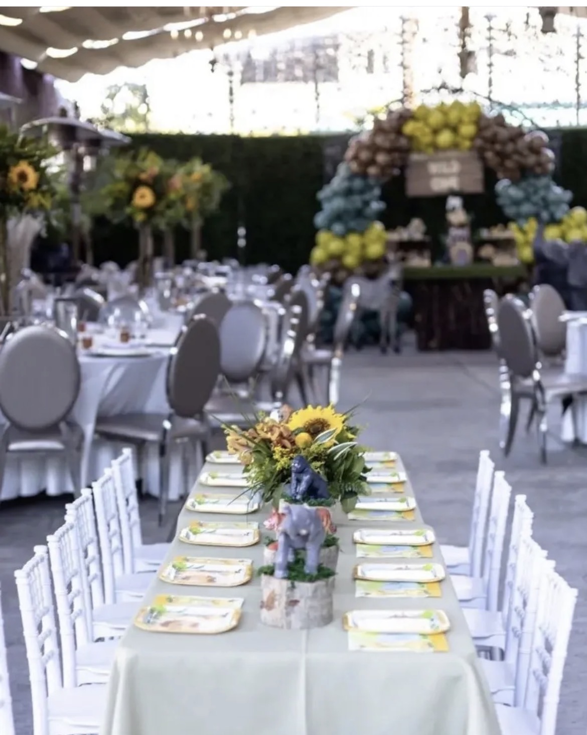 Long reception tables with white linens and silver seating